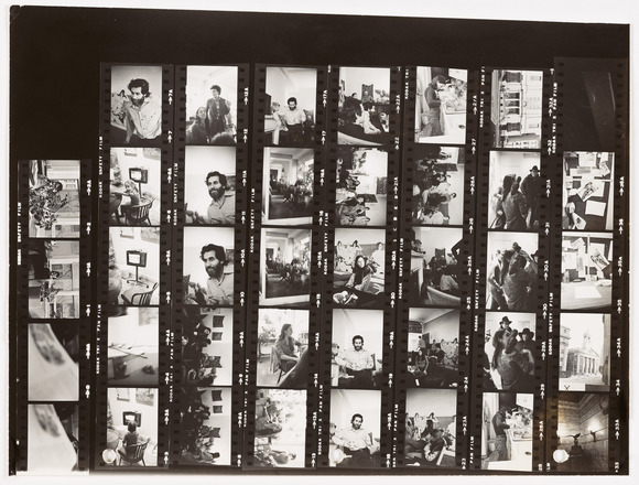 Black and white photographic contact sheet of images mostly depicting a group of people convened in an interior lounge or office setting. Some images depict figures individually or in small groups. 