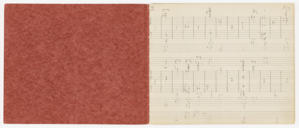 Two-page spread of bound book, showing left interior of red cover and right page with eight printed staves and handwritten musical notation in pencil.