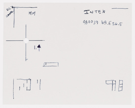 Transparency sheet with black handwritten text and symbols. Left side of page features, from top to bottom, two lines forming a right angle labeled “MM” and a right-pointing arrow above two perpendicular lines forming a cross with a hole punched through the center labeled with “1.” ; and an upward-pointing arrow above short vertical line segments. Center of page empty. Bottom right of page features two shapes created from boxes stacked three high. 