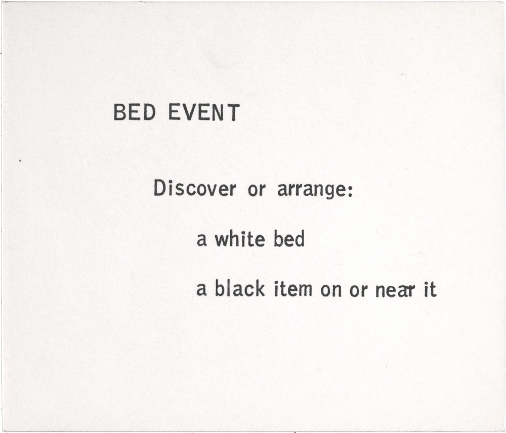 Bed Event: Discover or arrange: a white bed a black item on or near it