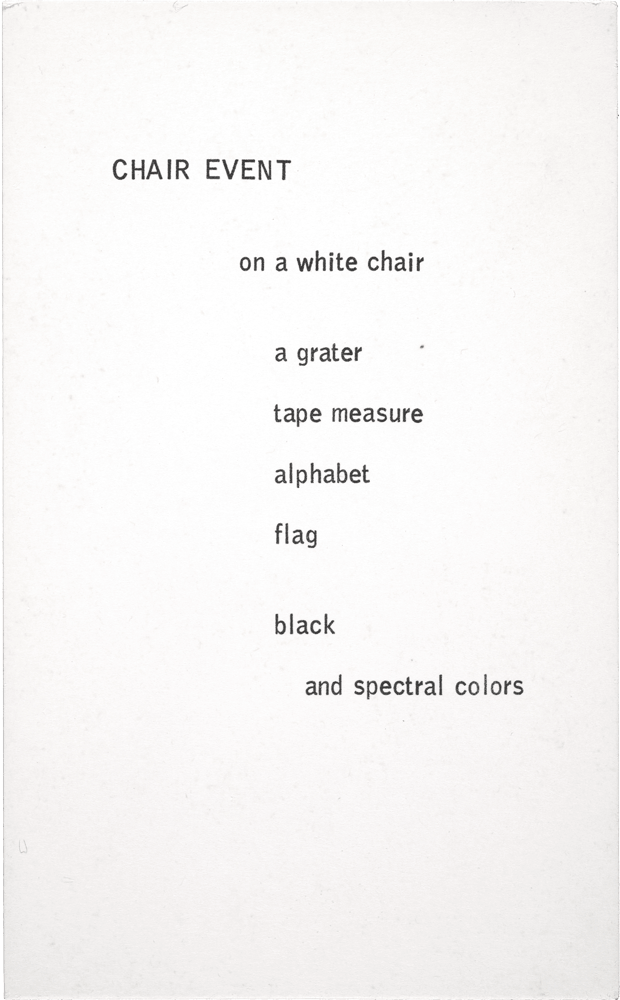 Chair Event: on a white chair a grater tape measure alphabet flag black and spectral colors