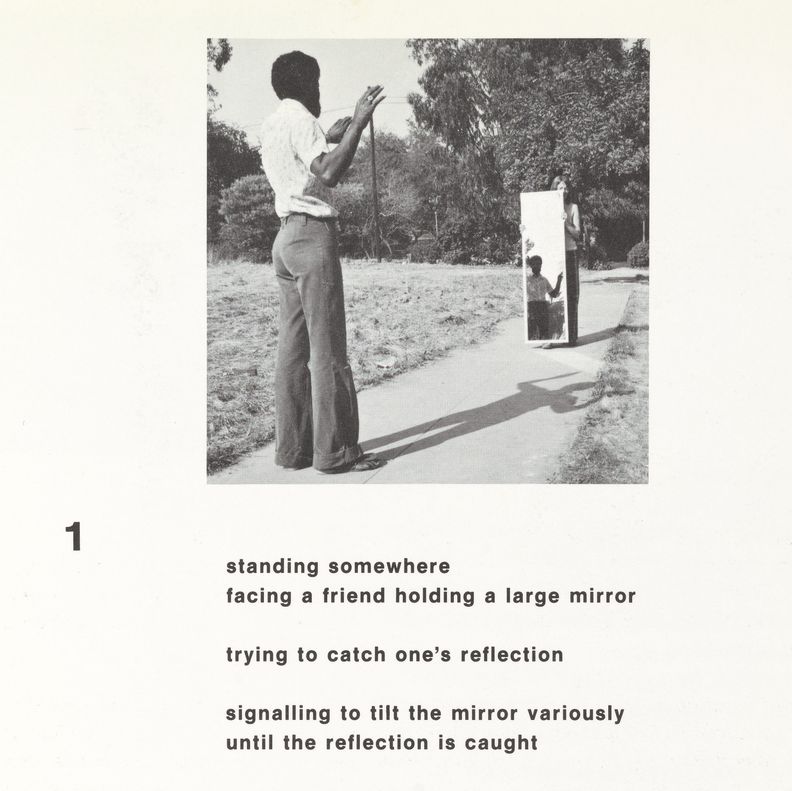 Square white paper with square black and white photograph at center of a man outdoors facing away from camera and toward a woman holding a body-length mirror. The man's reflection is visible in the mirror. The bottom half contains five lines of bold black print in English. The number 1 is present on the left in line with first line of text.