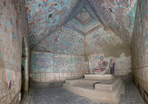 On a platform inside Cave 85 sit statues of the Buddha and two disciples.  Colorful paintings enliven the walls
