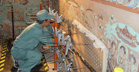 conservator working on temple cave wall